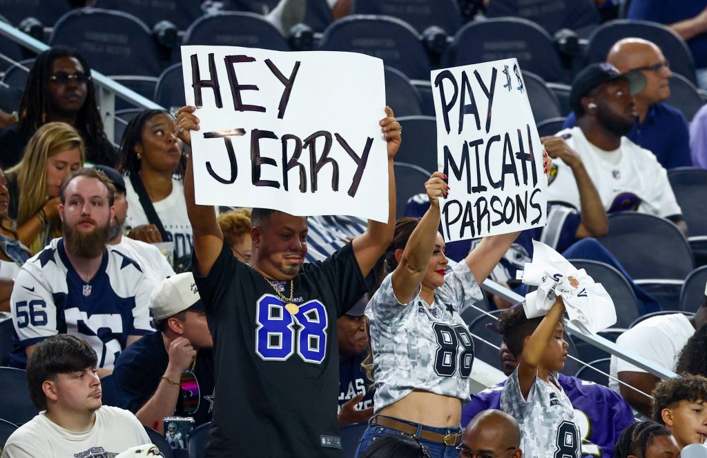 Dallas Cowboys Fans halten ein Schild hoch für Micah Parsons gerichtet an Jerry Jones