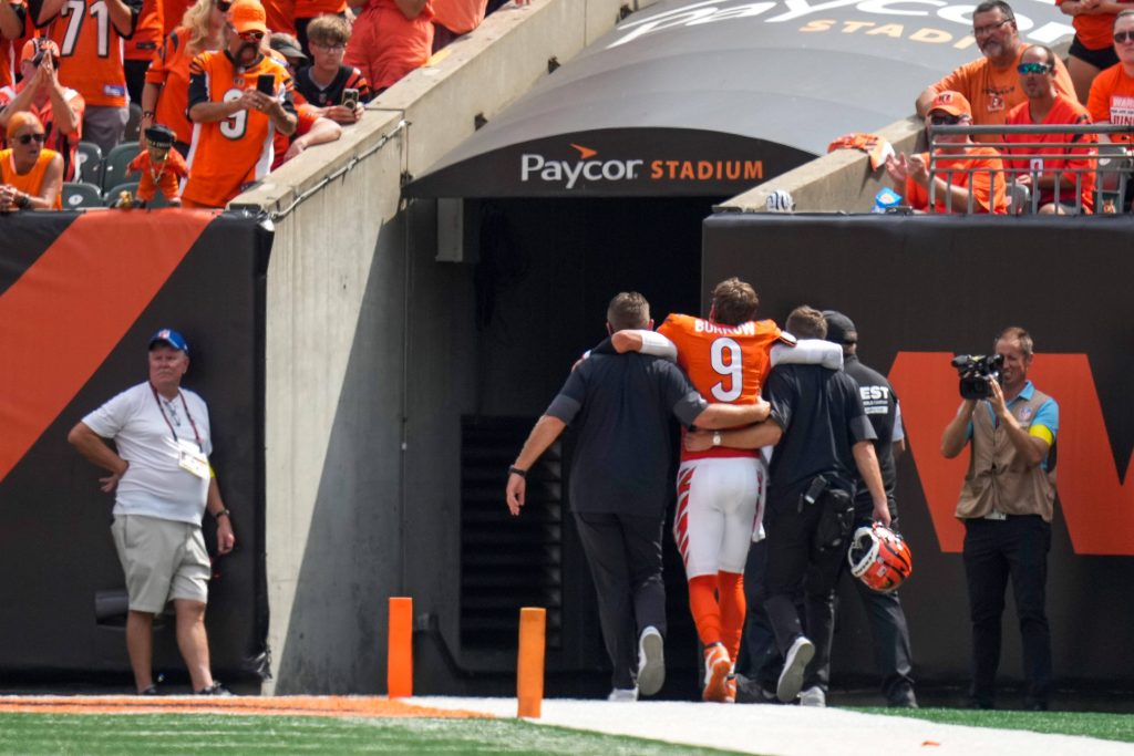 Cincinnati Bengals Quarterback Joe Burrow #9 wird im zweiten Viertel des Spiels gegen die Jacksonville Jaguars verletzt vom Feld begleitet.