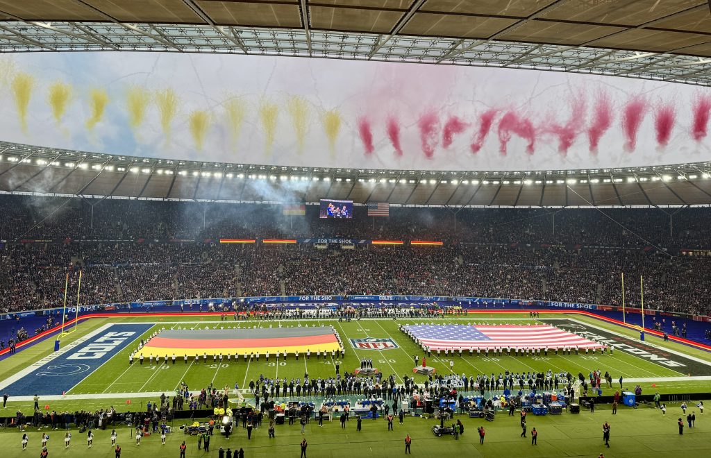 NFL Berlin Game 2025 – Olympiastadion während der Nationalhymnen mit den Flaggen Deutschlands und der USA.
