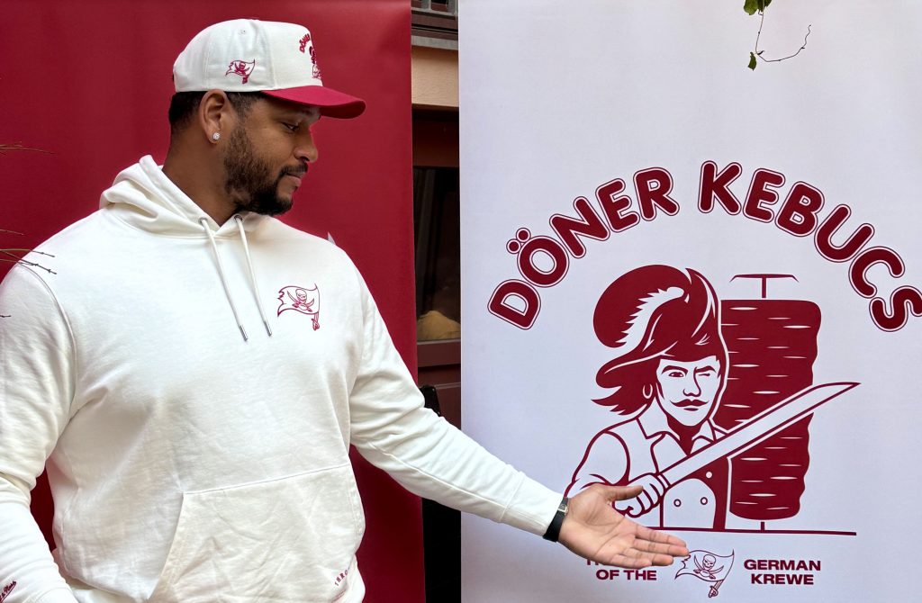 Ex-NFL-Spieler und Super-Bowl-Champion William Gholston (ehemals Tampa Bay Buccaneers) zu Gast beim Döner Kebucs Event. Der ehemalige Defensive End zeigt sich gut gelaunt, posiert mit Fans und genießt landestypische Spezialitäten. Das Event verbindet amerikanischen Sportsgeist mit türkisch-deutscher Streetfood-Kultur.