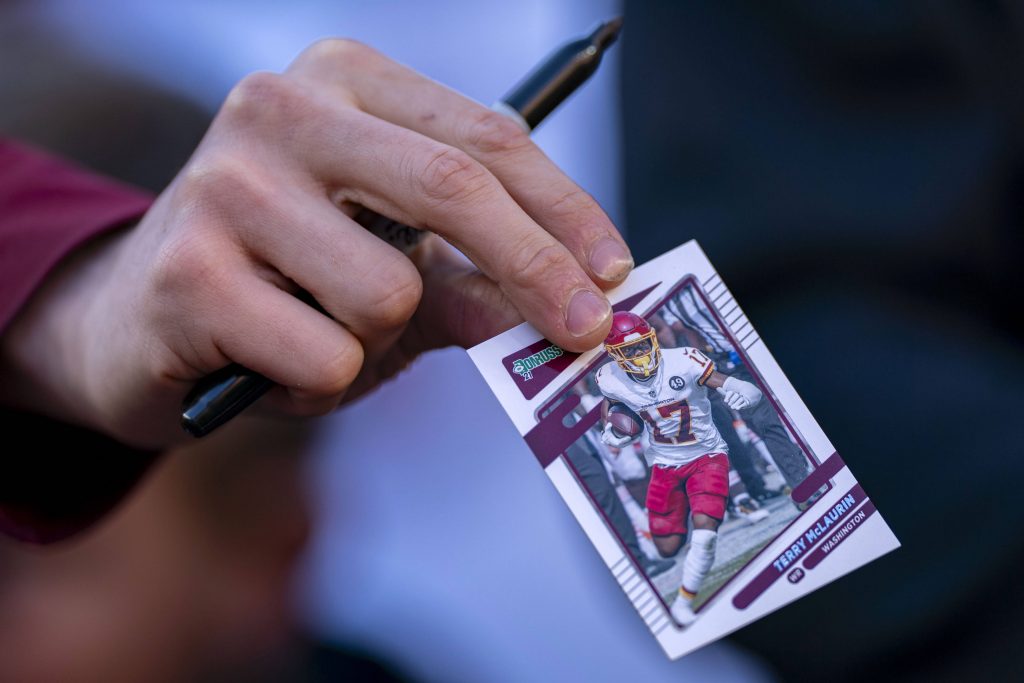 Eine Hand hält eine NFL Trading Card – im Zentrum der Diskussion um Grading-Giganten PSA und Beckett und die Zukunft des Sammelkarten-Marktes.