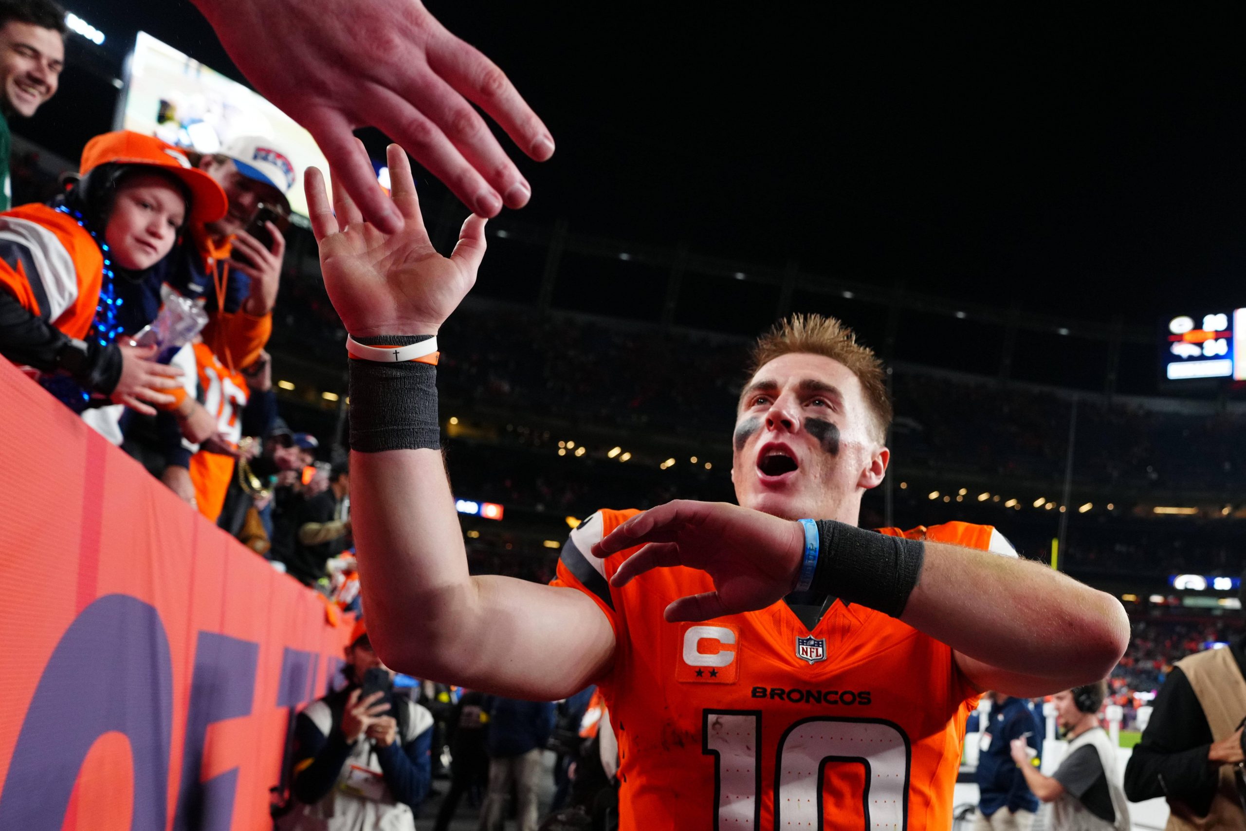 Bo Nix #10 feiert nach dem Sieg der Denver Broncos gegen die Green Bay Packers gemeinsam mit den Fans das gelöste Playoff-Ticket in NFL Week 15