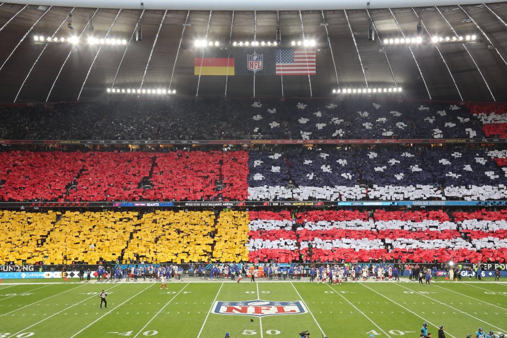 Die Allianz Arena beim NFL-Spiel in Deutschland – US- und Deutschland-Flagge auf der Tribüne. 2026 empfangen die Detroit Lions München zum nächsten Highlight.
