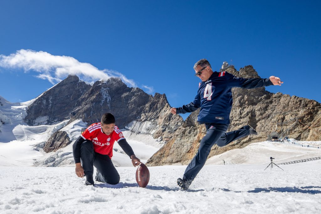Adam Vinatieri beim Field Goal-Weltrekord auf 3.449,64 Metern – vor der Kulisse der Schweizer Alpen.
