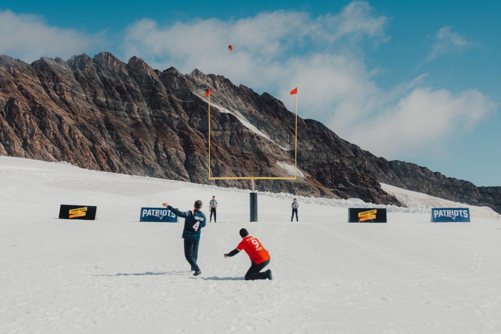 Adam Vinatieri beim Rekord-Kick auf 3.449,64 Metern – vor der Kulisse der Schweizer Alpen. | Quelle: New England Patriots / jungfrau.ch